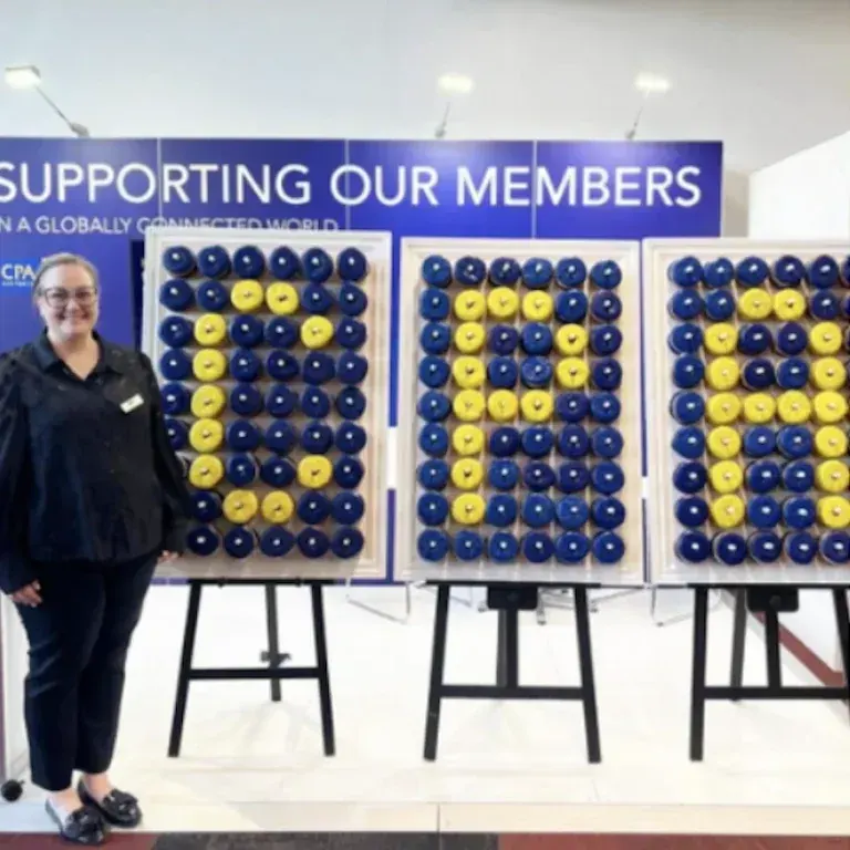 Corporate donut wall hire with branded blue and yellow donuts at a member event
