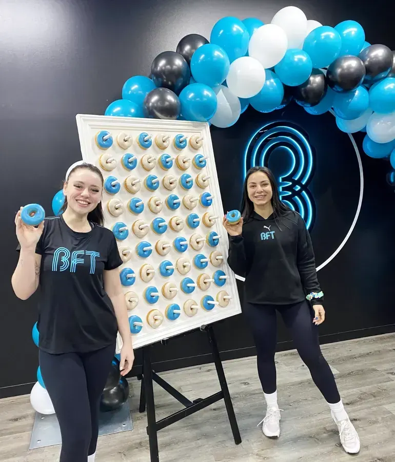 Fitness studio launch doughnut wall with blue and white donuts and balloons