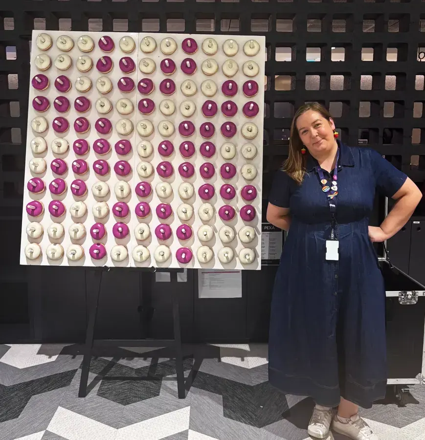 Corporate donut wall hire Sydney with purple and white branded donuts
