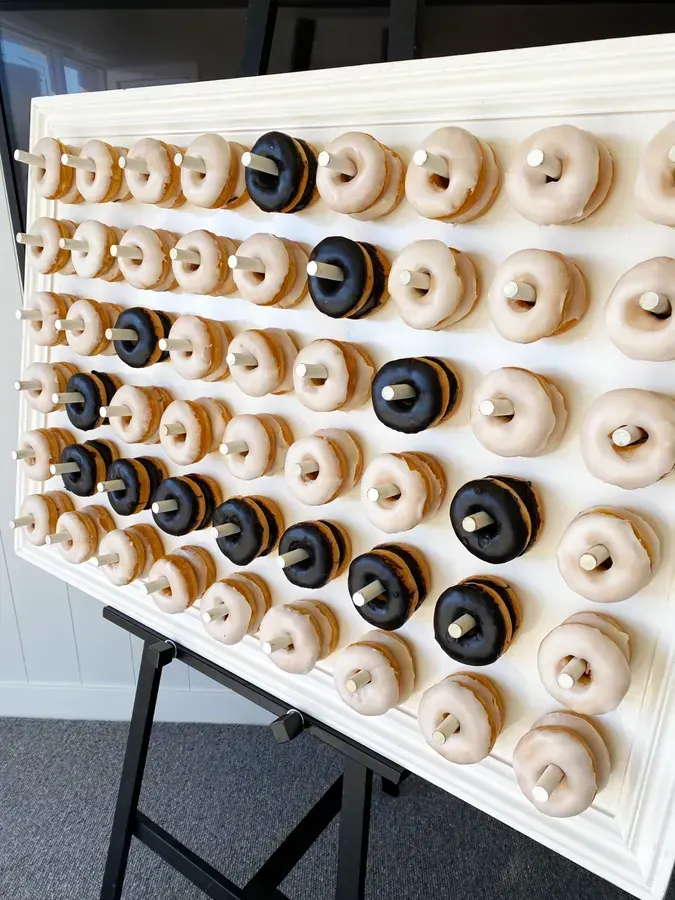 White doughnut wall station styled with fresh donuts for an event