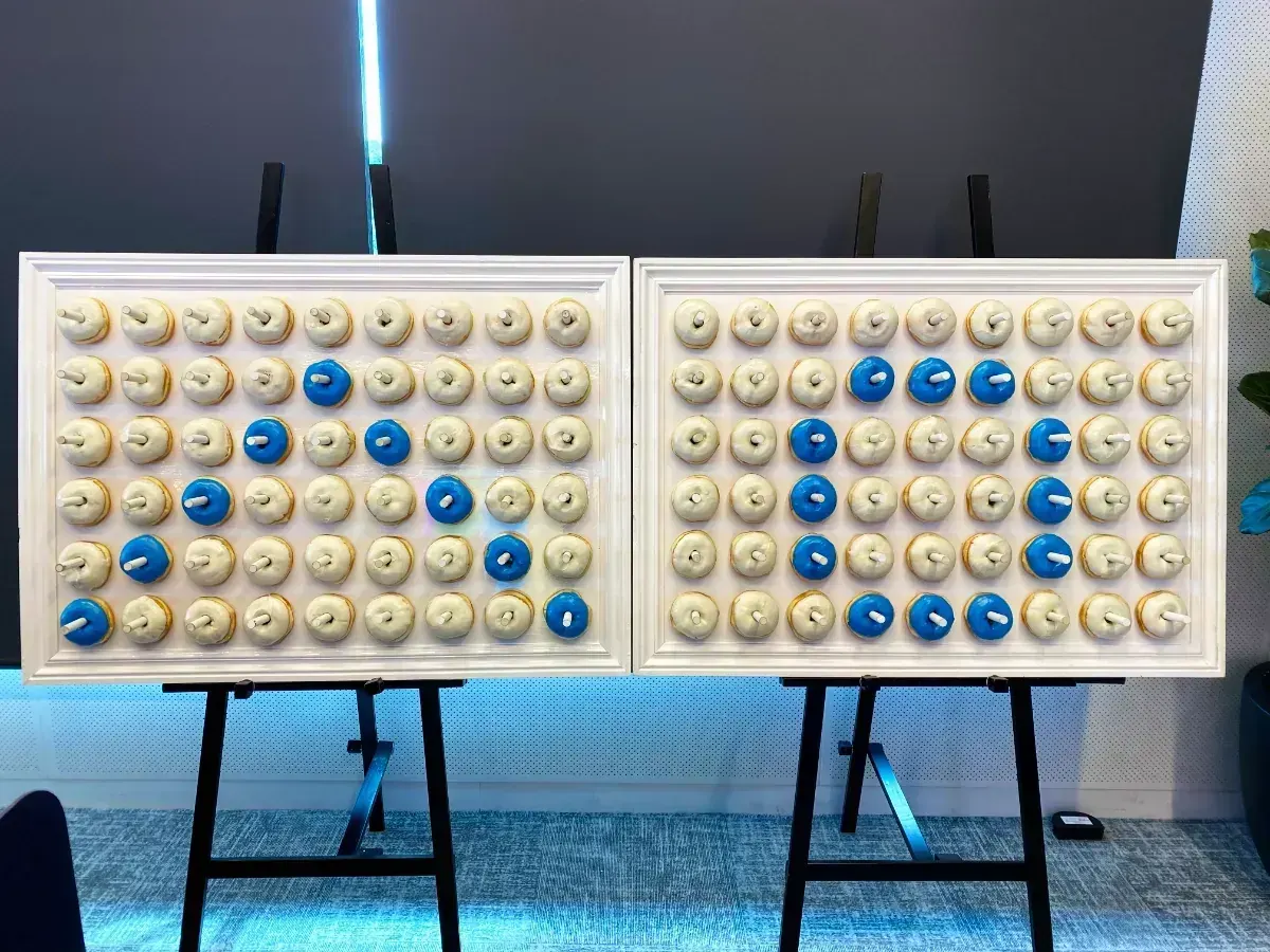 Donut wall hire - twin white donut walls styled with glazed donuts for a corporate event