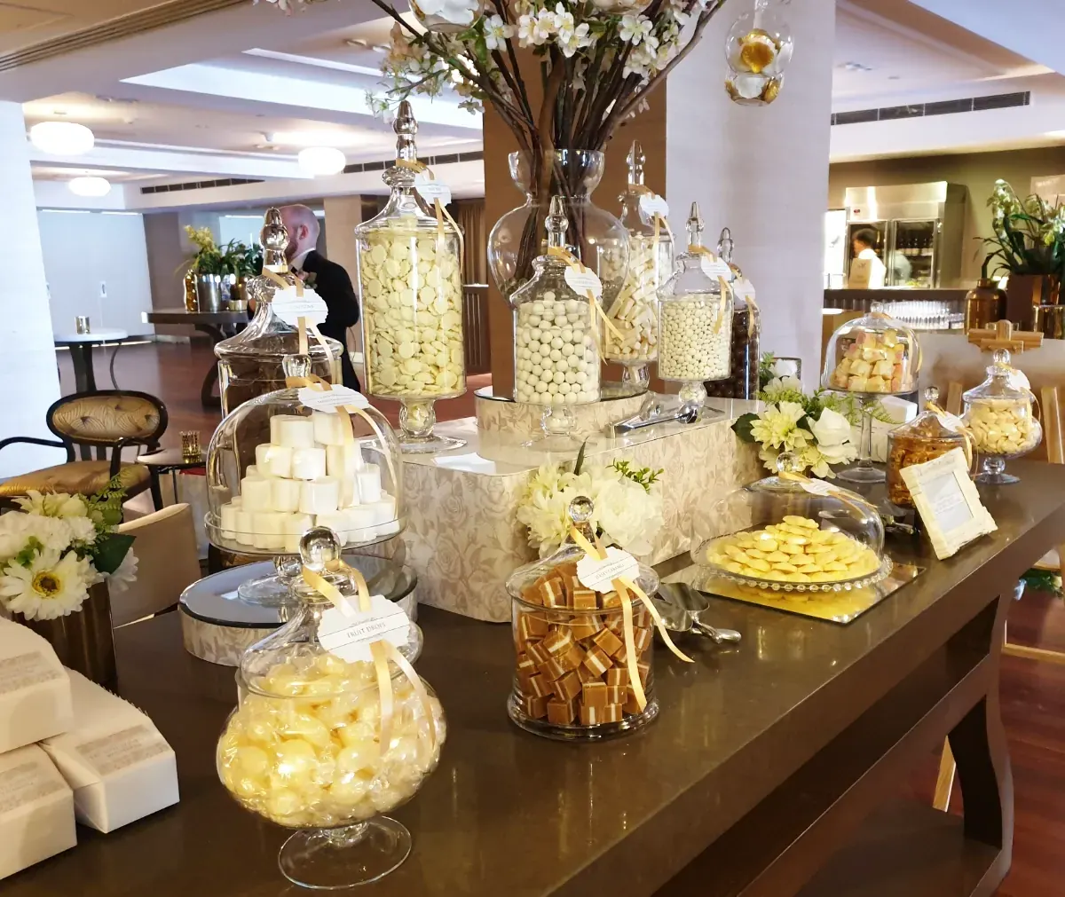 Luxury lolly buffet styled with jars, florals and candy displays for a premium event